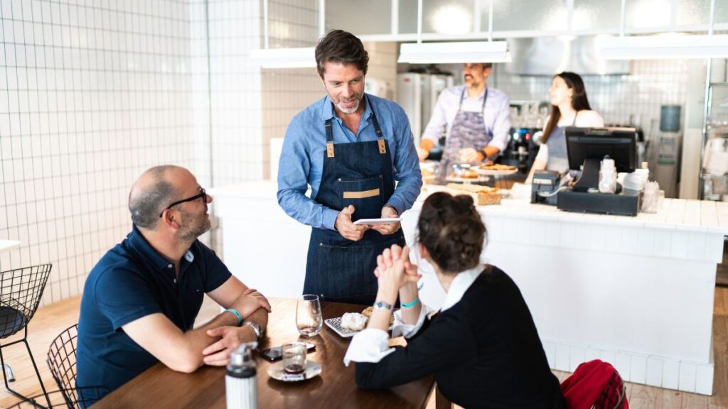camarero tomando pedido con tablet TPV en restaurante moderno