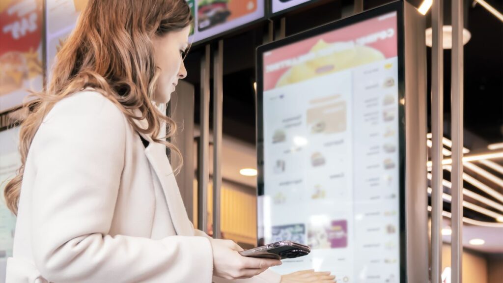 cliente utilizando pantalla digital de pedido en restaurante con sistema TPV